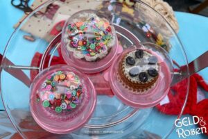 Das Bild zeigt gehäkelte Cupcakes unter kleinen Glashauben als Bildmetapher für Storytelling (Photocredit: Petra Welz, Geld & Rosen, Düsseldorf)