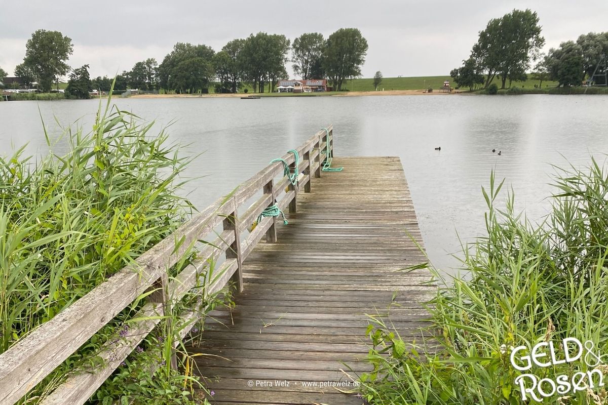 Das Bild zeigt einen Steg ins Wasser an einem Fluss als Bildmetapher für die Fördermittel-Beantragung (Photocredit: Petra Welz, Geld & Rosen, Düsseldorf)
