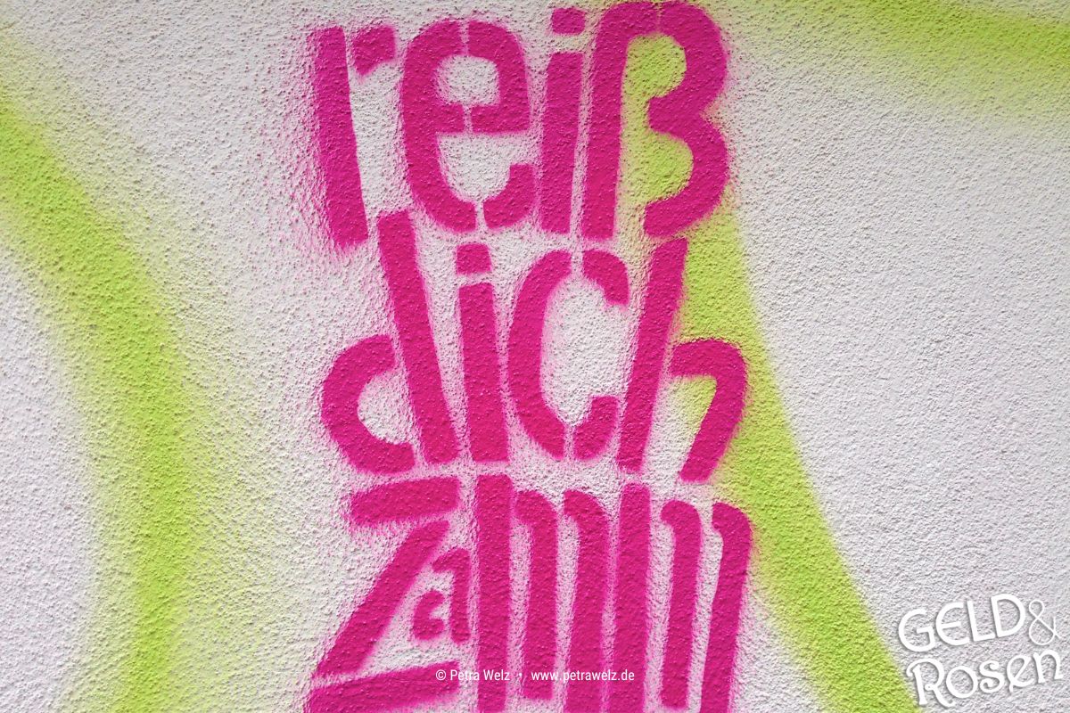 Das Bild enthält enthält ein Graffiti mit dem pinkfarbenen Schriftzug "Reiß dich zamm" als Analogie zur eigenen Unternehmensführung (Photocredit: Petra Welz, Geld & Rosen, Düsseldorf)