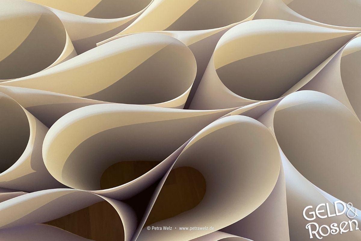 Das Bild zeigt mehrere in einer verschobene Papierblätter – als Bildmetapher für Tools, um Abhängigkeiten zu reduzieren (Bild: eigenes Material Petra Welz, Geld & Rosen, Düsseldorf).